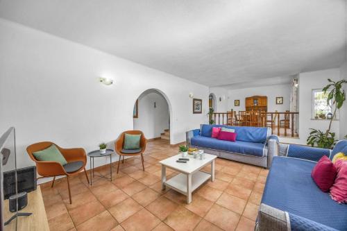 a living room with a blue couch and chairs at Villa Ricardo by Villa Plus in Carvoeiro