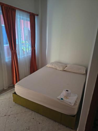 a bed sitting in a room with a window at Hotel Mar Azul in Acacías