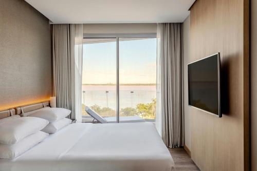 a hotel room with two beds and a large window at Marriott Corrientes in Corrientes