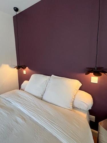 a bedroom with a white bed with two pillows at Nuit Céleste Studio élégant avec parking Centre Morteau in Morteau