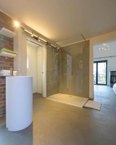 a large room with a glass door in a building at Les Pieds au vert in Limbourg