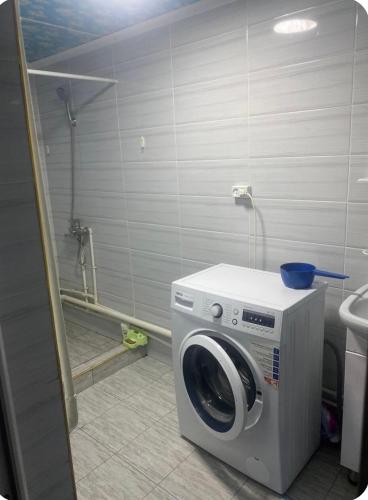 a washing machine in a bathroom with a shower at Nurs Home in Dzhenish
