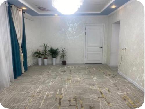 a room with a hallway with a door and plants at Nurs Home in Dzhenish