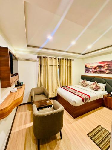 a hotel room with a bed and a chair at Hotel Attic Empire in Kathmandu