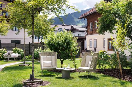 three chairs and a table in a yard at Landhaus Steiner in Altenmarkt im Pongau