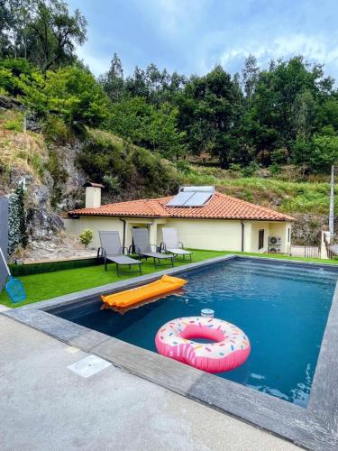 a house with a swimming pool with a float in it at Relax House - Casa Castor in Valdosende