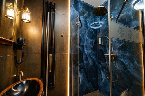 a bathroom with a glass shower with a sink at Boutique rooms Fabrika in Děčín