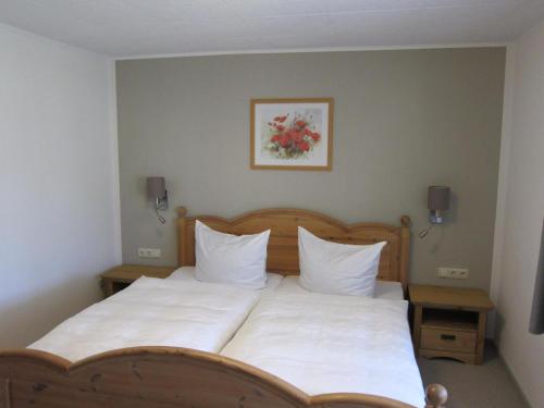 a bedroom with a large bed with white sheets and pillows at Ferienwohnungen Haseloff in Kurort Oberwiesenthal