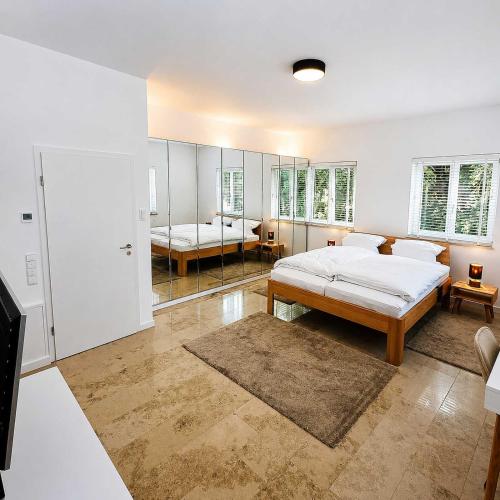 a bedroom with a bed and a mirror at Villa Kirnach Private Spa Retreat im Allgäu in Biessenhofen