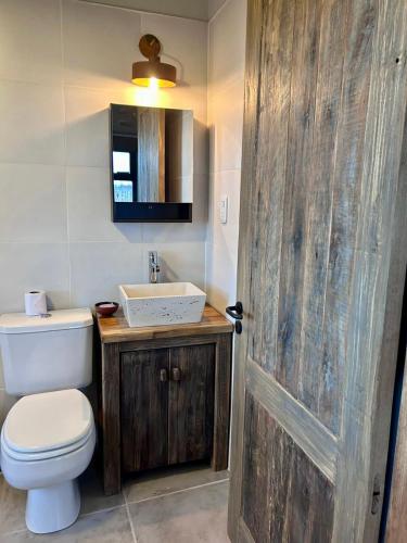 a bathroom with a toilet and a sink and a door at Finca Rosablanca Casa Jazmin in Vista Flores