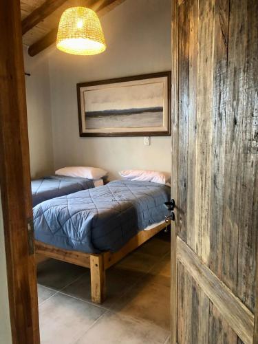 two twin beds in a room with a door at Finca Rosablanca Casa Jazmin in Vista Flores