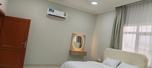 a bedroom with a bed and a mirror and a window at فلل فاخرة للإيجار صلالة Salalah Villas in Salalah