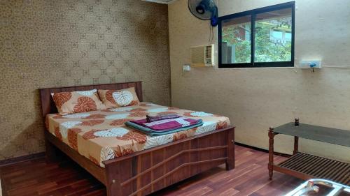 a bedroom with a bed with a window and a table at WeK Homes in Kumbla