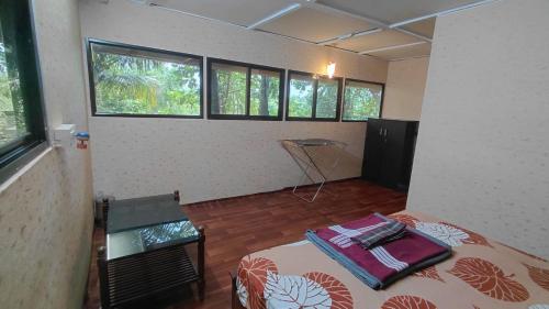 a room with a bed in a room with windows at WeK Homes in Kumbla