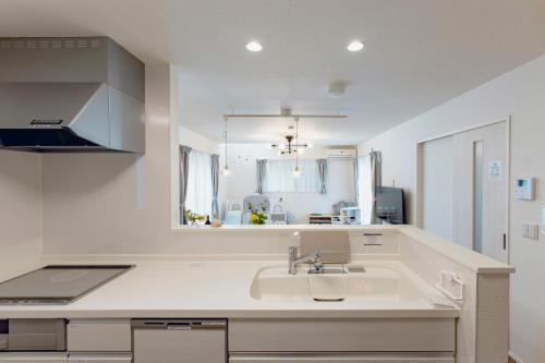 a white kitchen with a sink and a window at Sion MINATO in Nagoya