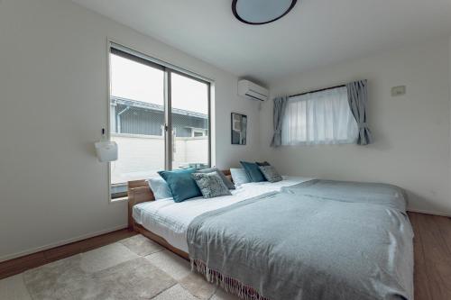 a bedroom with a large bed and a large window at Sion MINATO in Nagoya