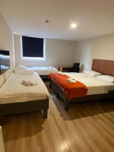 ein Hotelzimmer mit zwei Betten und einem Fernseher in der Unterkunft Ambient Hotel in Domžale