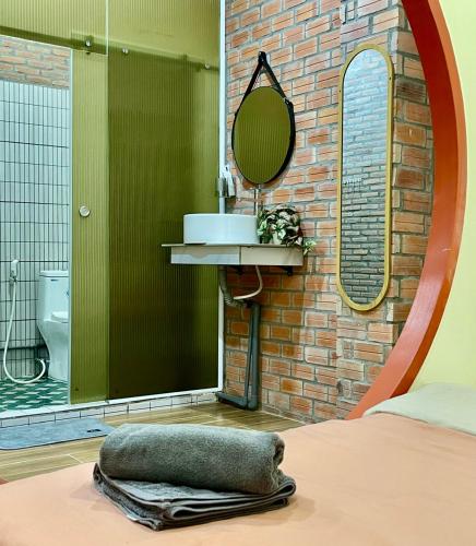 a bathroom with a sink and a mirror and a bed at The Miá home in Can Tho