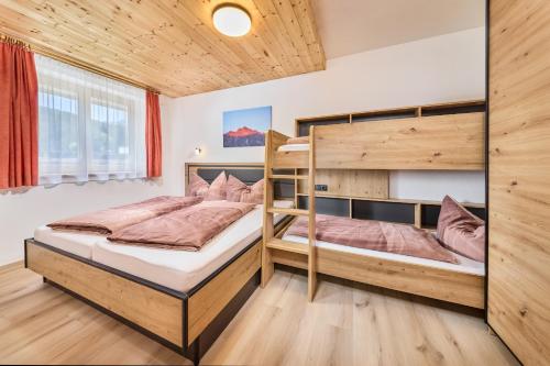 two bunk beds in a room with wooden walls at Appartement Lea in Niederthai