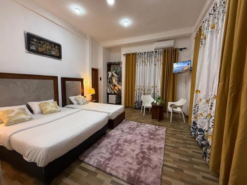 a hotel room with two beds and a rug at Aurora White Bungalow Kandy in Kandy