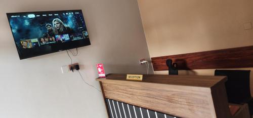 a flat screen tv hanging on a wall at Muzinge inn in Kagolomolo