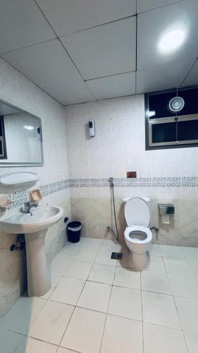 a bathroom with a white toilet and a sink at Haven Hub in Abu Dhabi