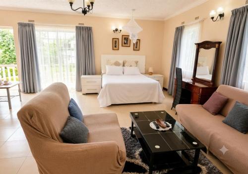 a hotel room with a bed and a living room at Deluxe Studio Suite with Kitchenette in Gaborone