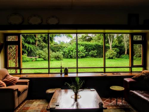 a living room with a large window and a table at The Researchers Rest in Arusha