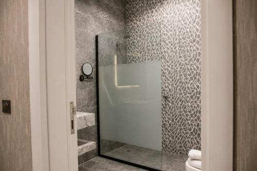 a bathroom with a glass shower with a toilet at Leaf Suites - أجنحة ليف in Ar Rass