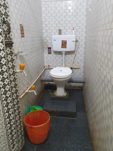 a small bathroom with a toilet in a stall at Foothill Lodge in Guwahati