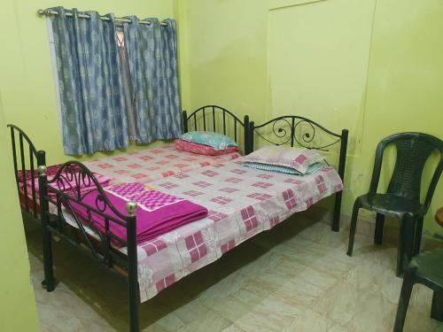 a bedroom with a bed and two chairs at Foothill Lodge in Guwahati