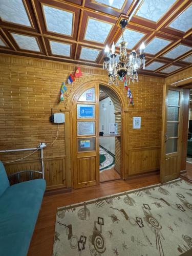 a living room with a chandelier and an entry way at Ho5tel House in Shymkent