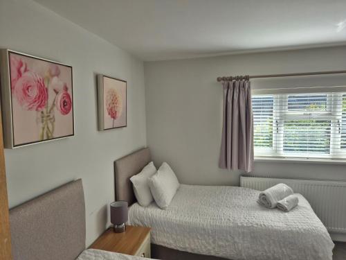a small room with two beds and a window at Terling House in Hythe