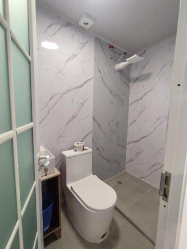 a bathroom with a white toilet and marble walls at Refugios del Pescador in San Cristóbal