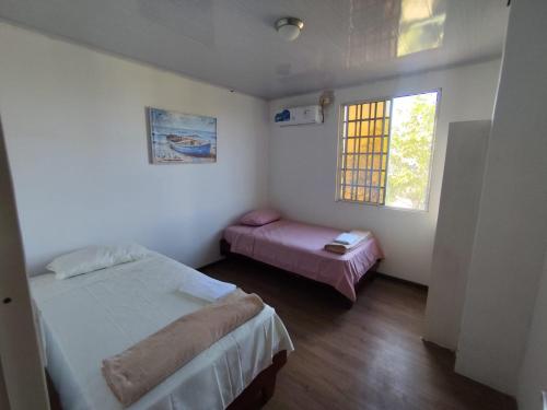 a small bedroom with two beds and a window at Refugios del Pescador in San Cristóbal