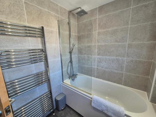a bathroom with a shower and a bath tub at Terling House in Hythe
