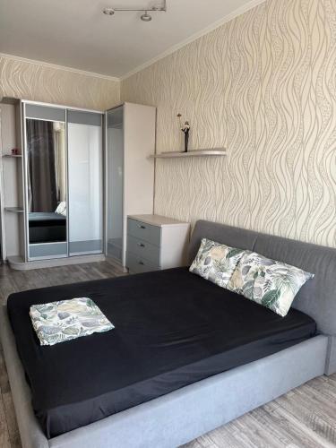 a bedroom with a large bed and a mirror at Апартаменти біля чорноморського моря in Fontanka