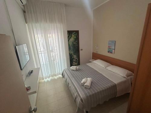 a bedroom with a bed with towels on it at Hotel Fattori in Cesenatico