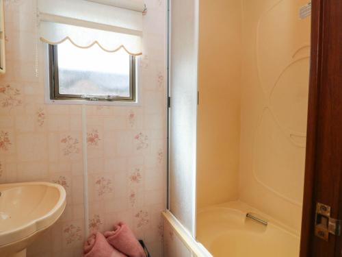 a bathroom with a shower and a tub and a sink at Buzzards Retreat in Wrexham