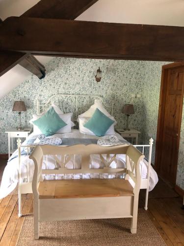 a bedroom with a white bed with green wallpaper at Hill Crest Gite in Vengeons
