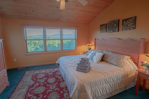 a bedroom with a large bed with a large window at Poppy’s Place Cabin in Dandridge