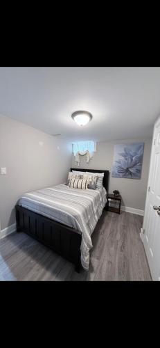 a bedroom with a large bed in a room at BASEMENT APARTMENT Two Bedrooms in Whitby