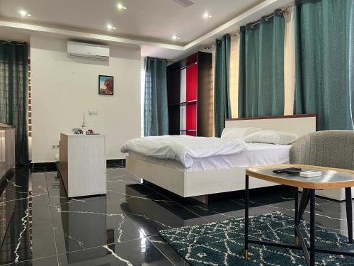 a bedroom with a bed and a table and a couch at Afse apartments Peduase in Aburi