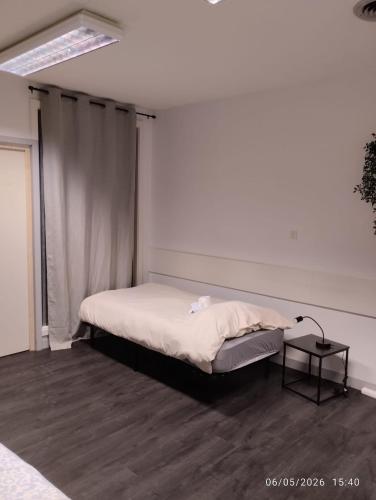 a small bedroom with a bed and a table at Le Lilas - 6 in Cherbourg en Cotentin
