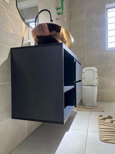 a bathroom with a sink and a toilet at Afse apartments Peduase in Aburi
