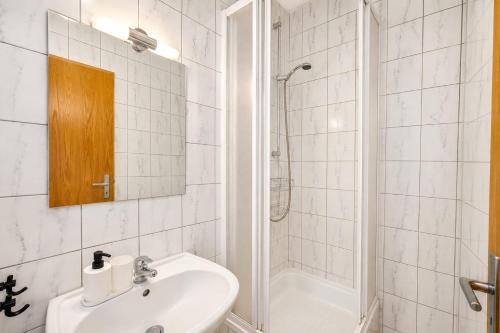 a white bathroom with a sink and a shower at Rennerka Horská bouda in Strážné