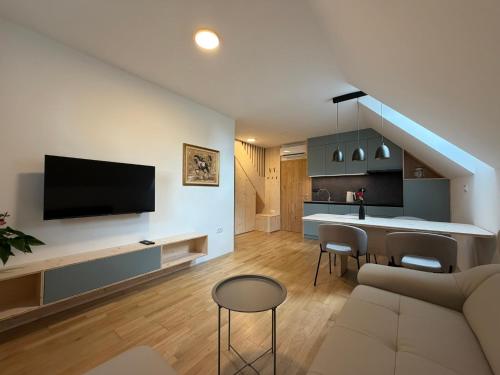 a living room with a couch and a table with chairs at Apartment House Belca in Preddvor