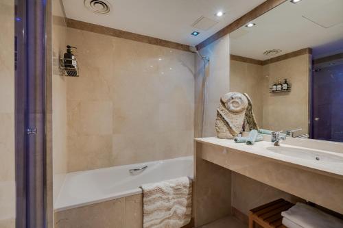a bathroom with a tub and a sink and a shower at Penthouse Duplex with Epic Views in Barcelona