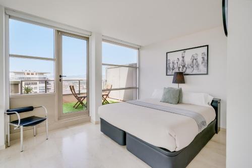 a bedroom with a bed and a large window at Penthouse Duplex with Epic Views in Barcelona