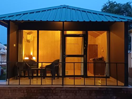 a house with a conservatory with a blue roof at Shivir Aranya - Wilderness Resort Sariska in Alwar